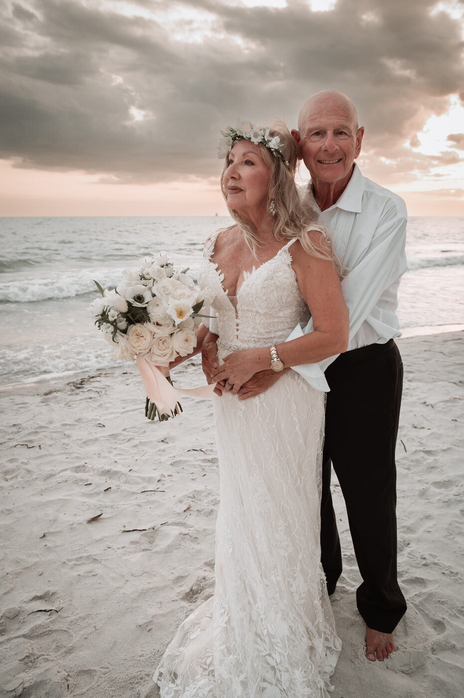 Beach elopement, older couple embracing at sunset