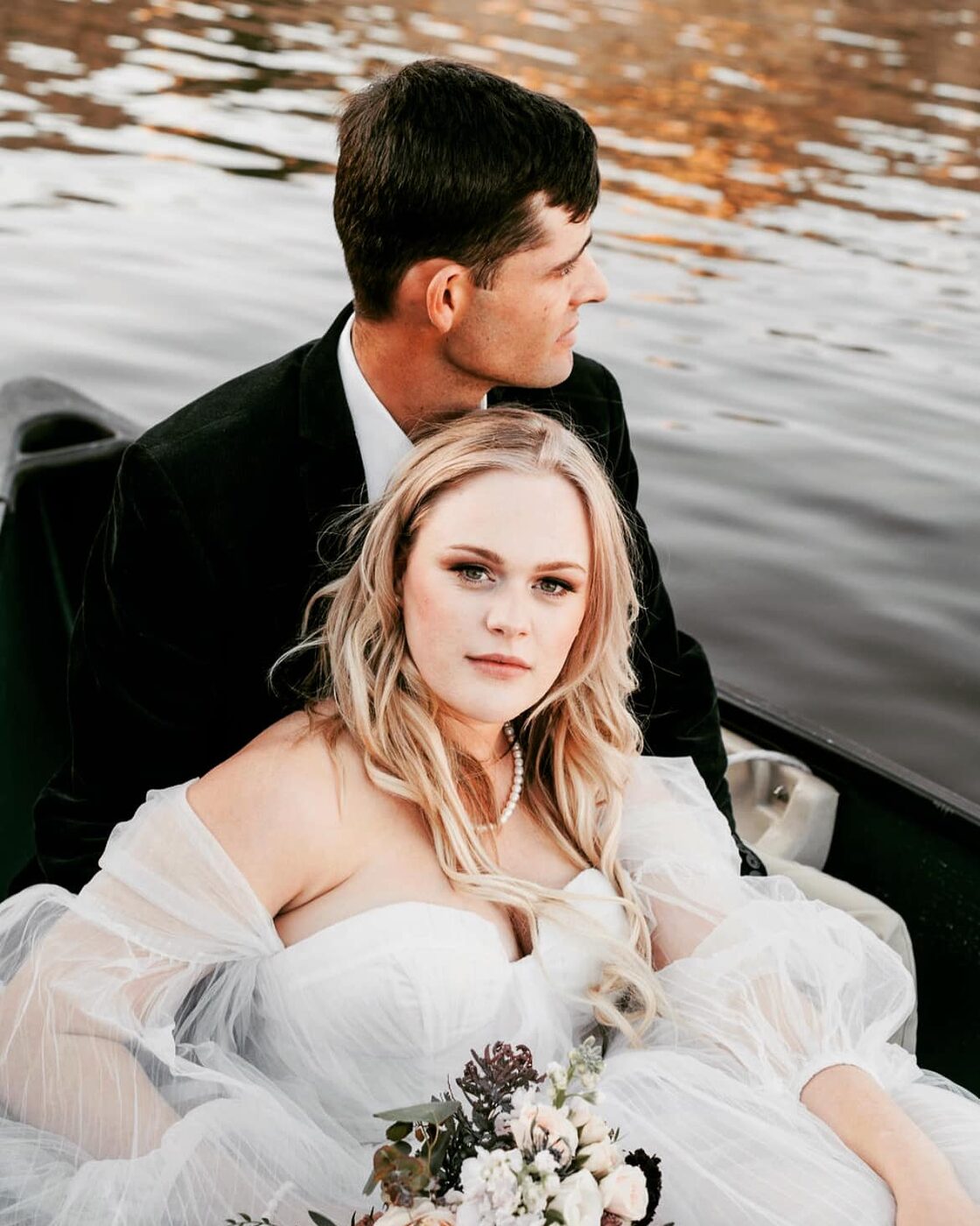 Bride and groom in a rowboat at golden hour