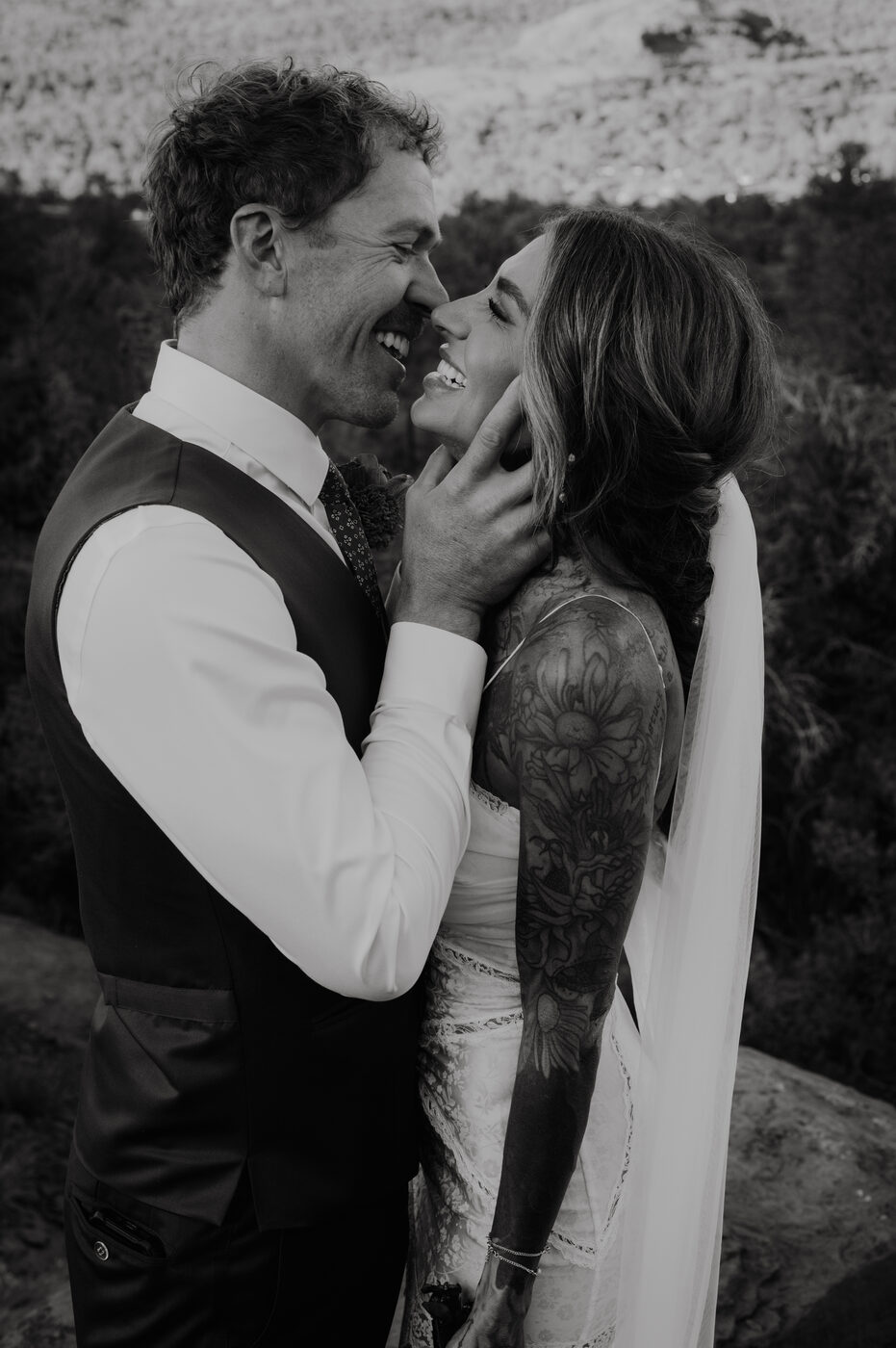 Groom and bride laughing together in the desert